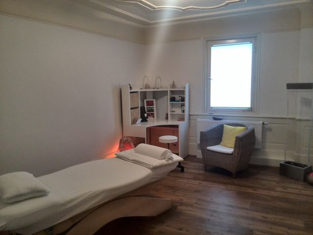 Behandlungsraum in Esslingen mit Liege, Regal und Sessel